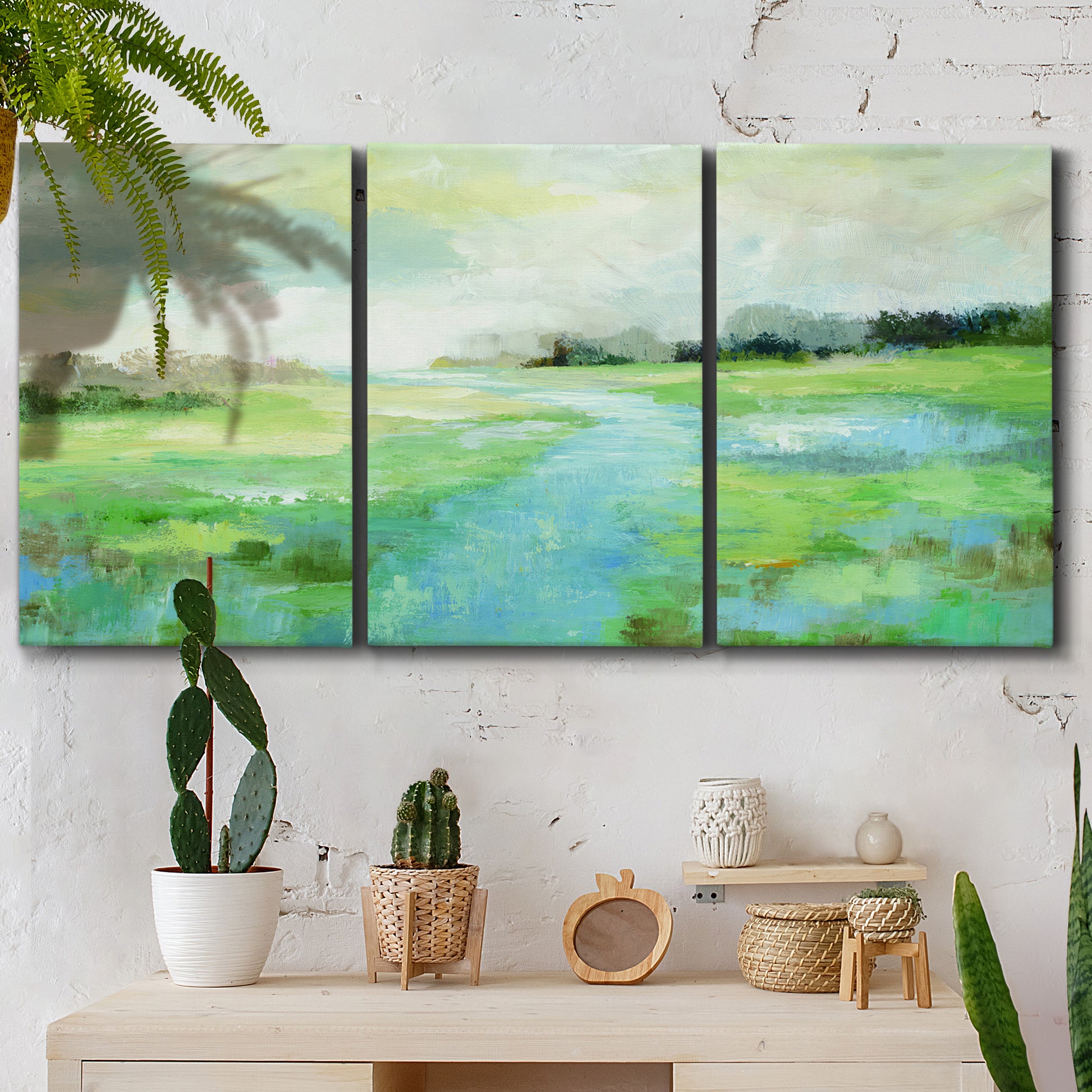 Three-panel canvas wall art featuring gentle stream winding through trees, displayed in a boho-chic entryway above a console table.