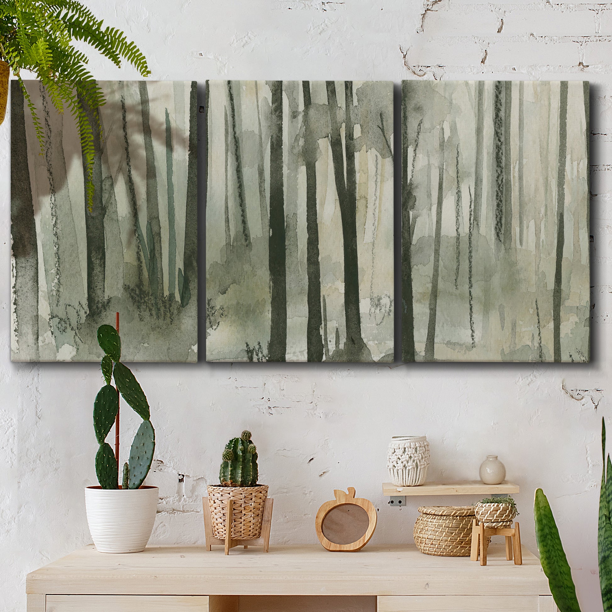 Three-panel canvas wall art featuring wooded forest path watercolor, displayed in a boho-chic entryway above a console table.