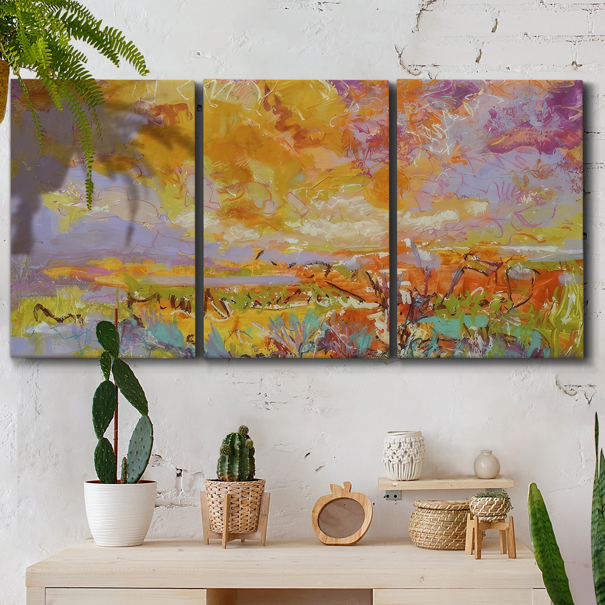 Three-panel canvas wall art featuring abstract meadow inspired color fields, displayed in a boho-chic entryway above a console table.