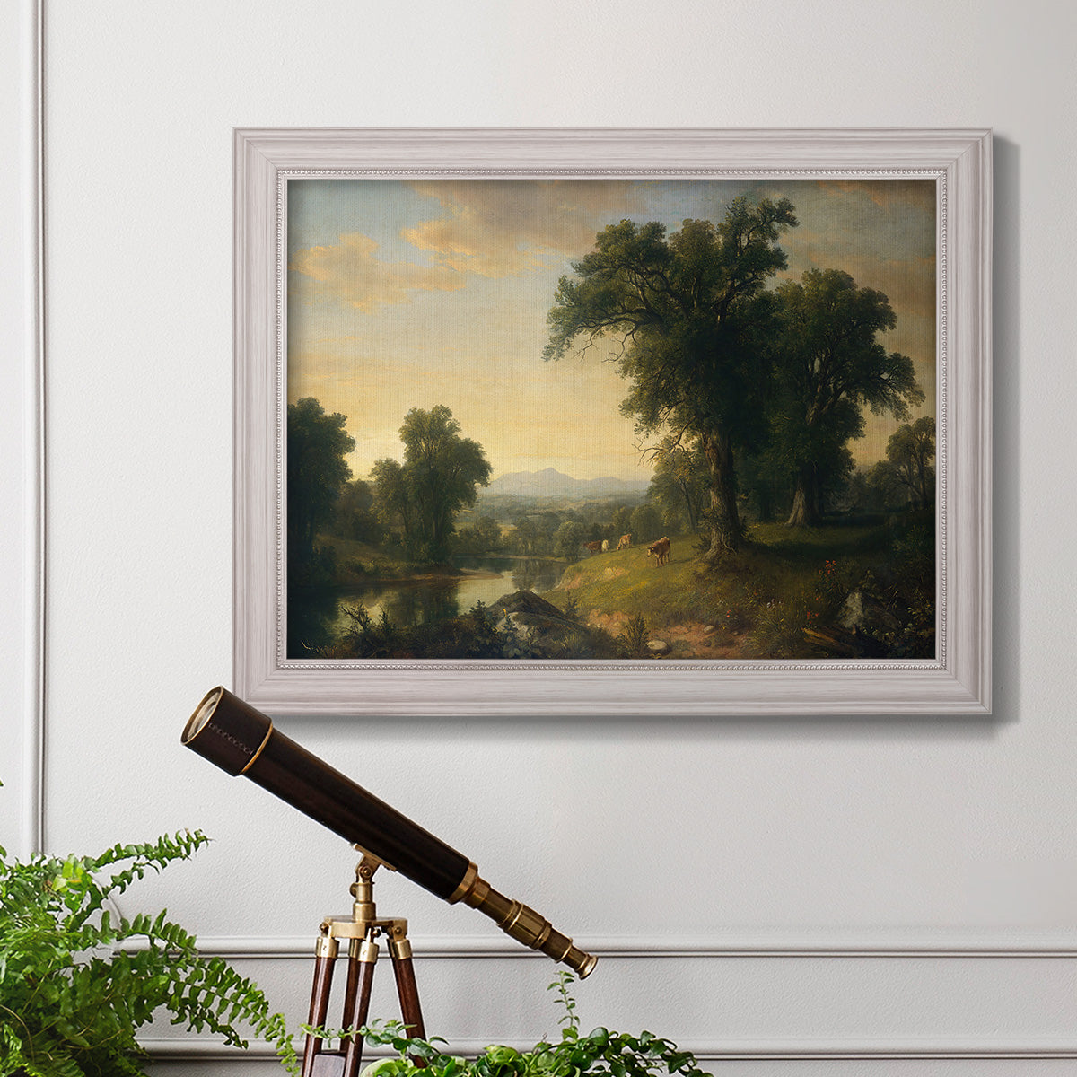 Traditional pastoral landscape painting by Asher Brown Durand in an ornate weathered white frame displayed in a light-toned interior setting.