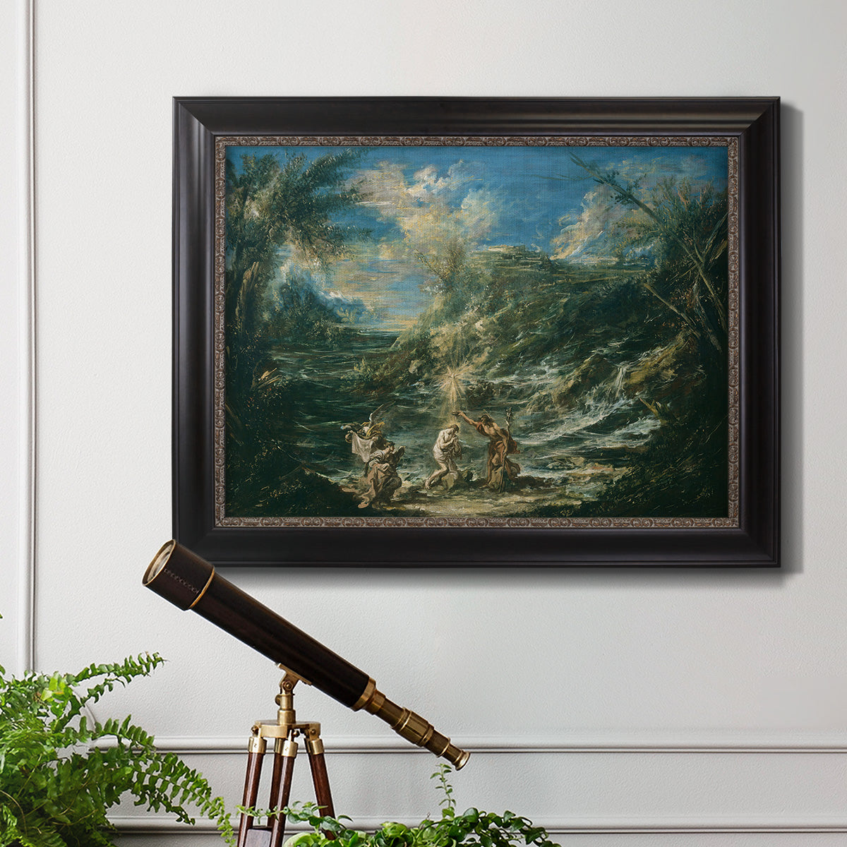 Religious landscape depicting the baptism of Christ by Alessandro Magnasco in an ornate black frame with gilded inner detail displayed in a light-toned interior setting.