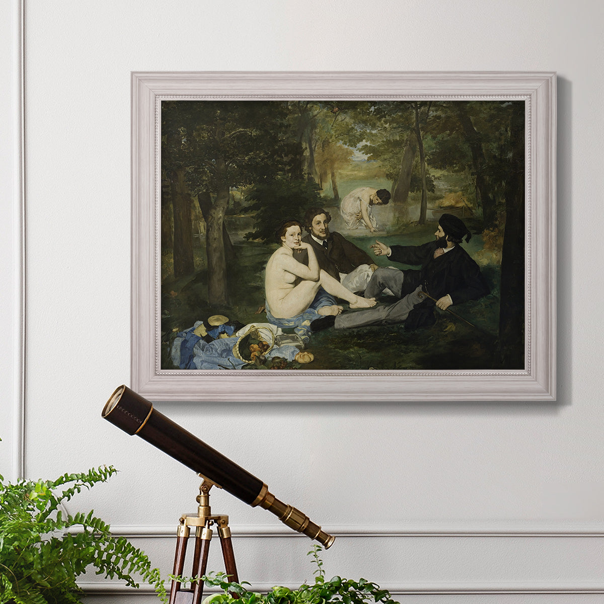Groundbreaking impressionist picnic scene by Édouard Manet in an ornate weathered white frame displayed in a light-toned interior setting.