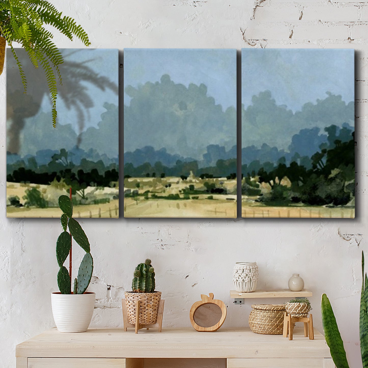 Three-panel canvas wall art featuring rural farmland landscape in watercolor, displayed in a boho-chic entryway above a console table.