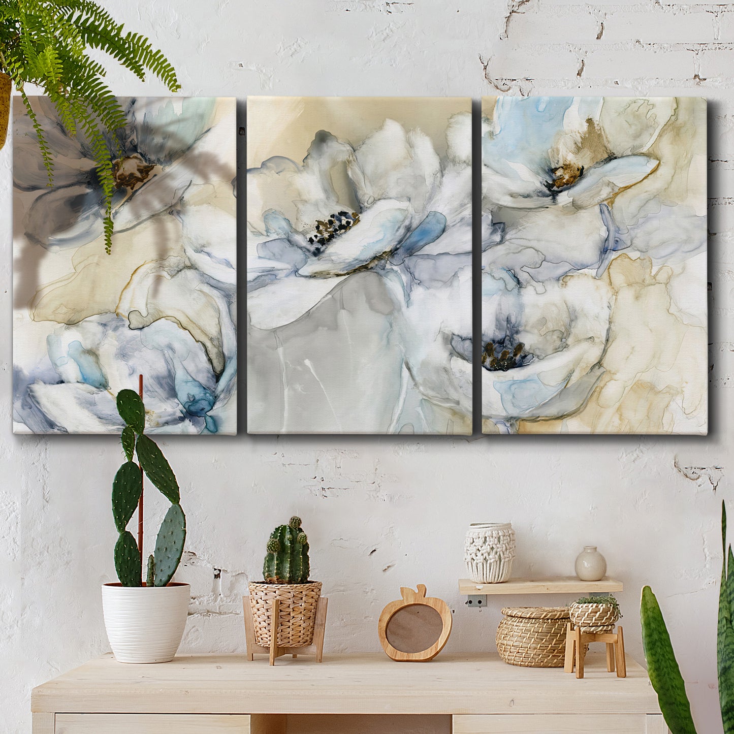 Three-panel canvas wall art featuring delicate watercolor floral blooms, displayed in a boho-chic entryway above a console table.