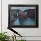 Impressionist rocky seascape by Claude Monet in an ornate black frame with gilded inner detail displayed in a light-toned interior setting.