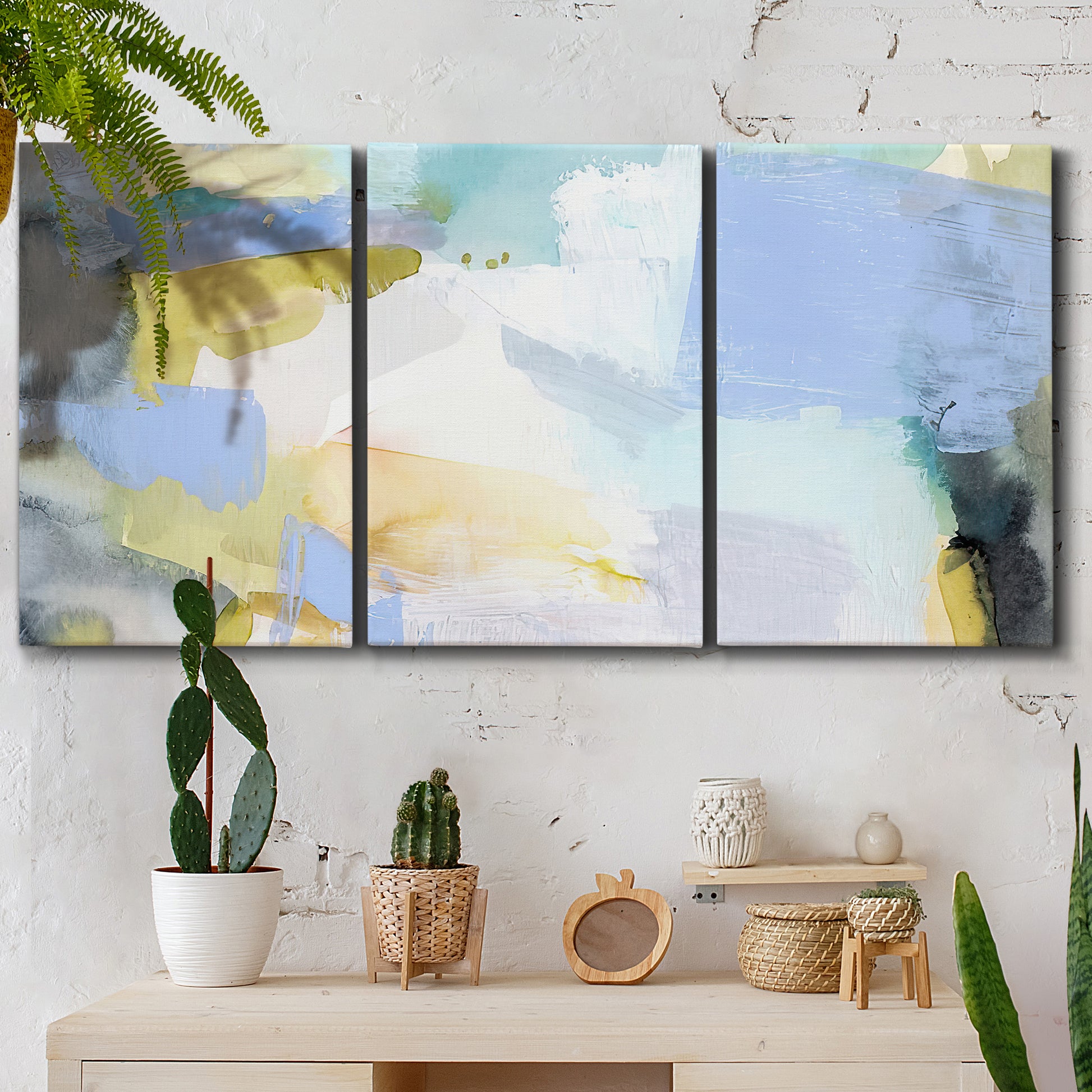 Three-panel canvas wall art featuring soft abstract spring watercolor tones, displayed in a boho-chic entryway above a console table.