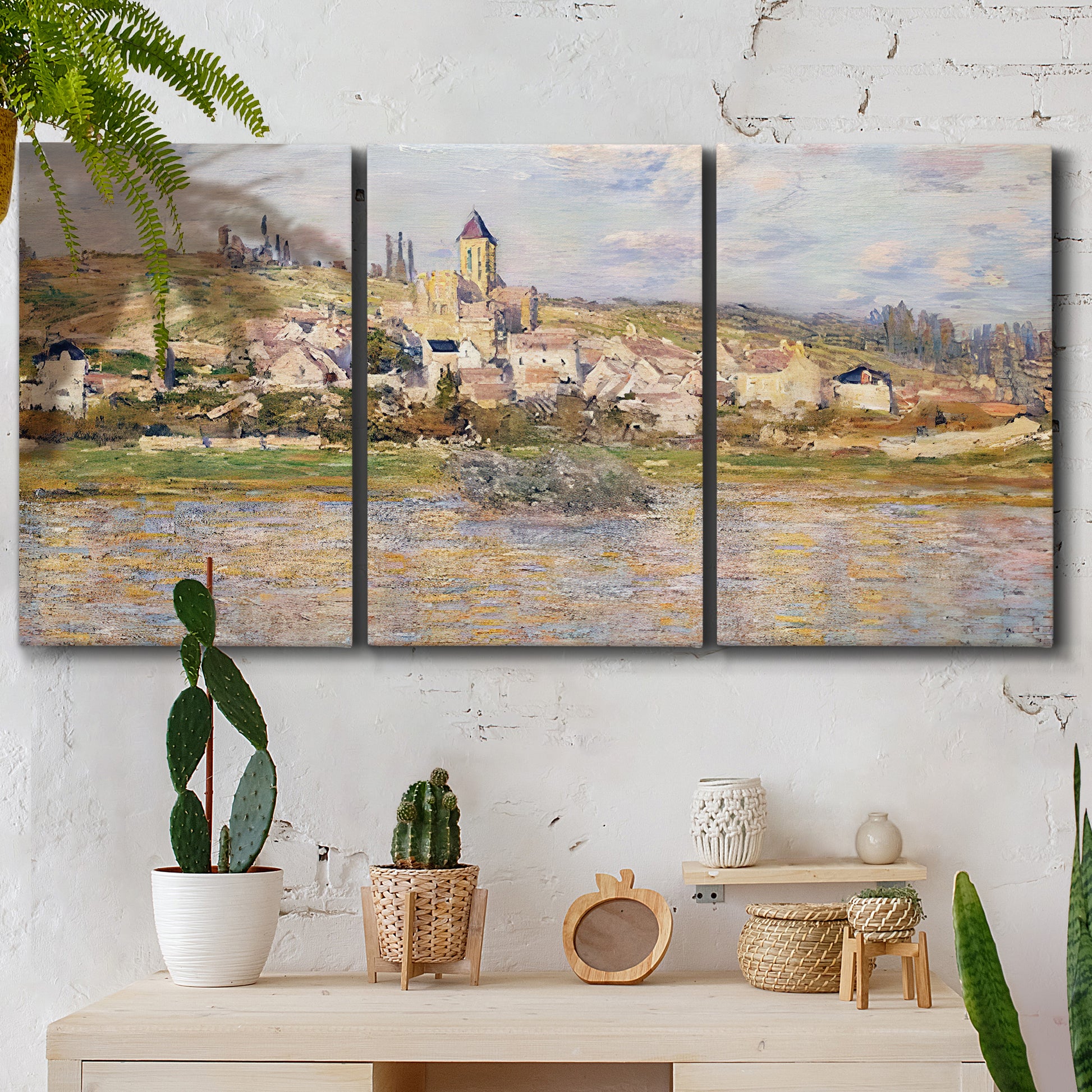 Three-panel canvas wall art featuring village overlooking river valley, displayed in a boho-chic entryway above a console table.