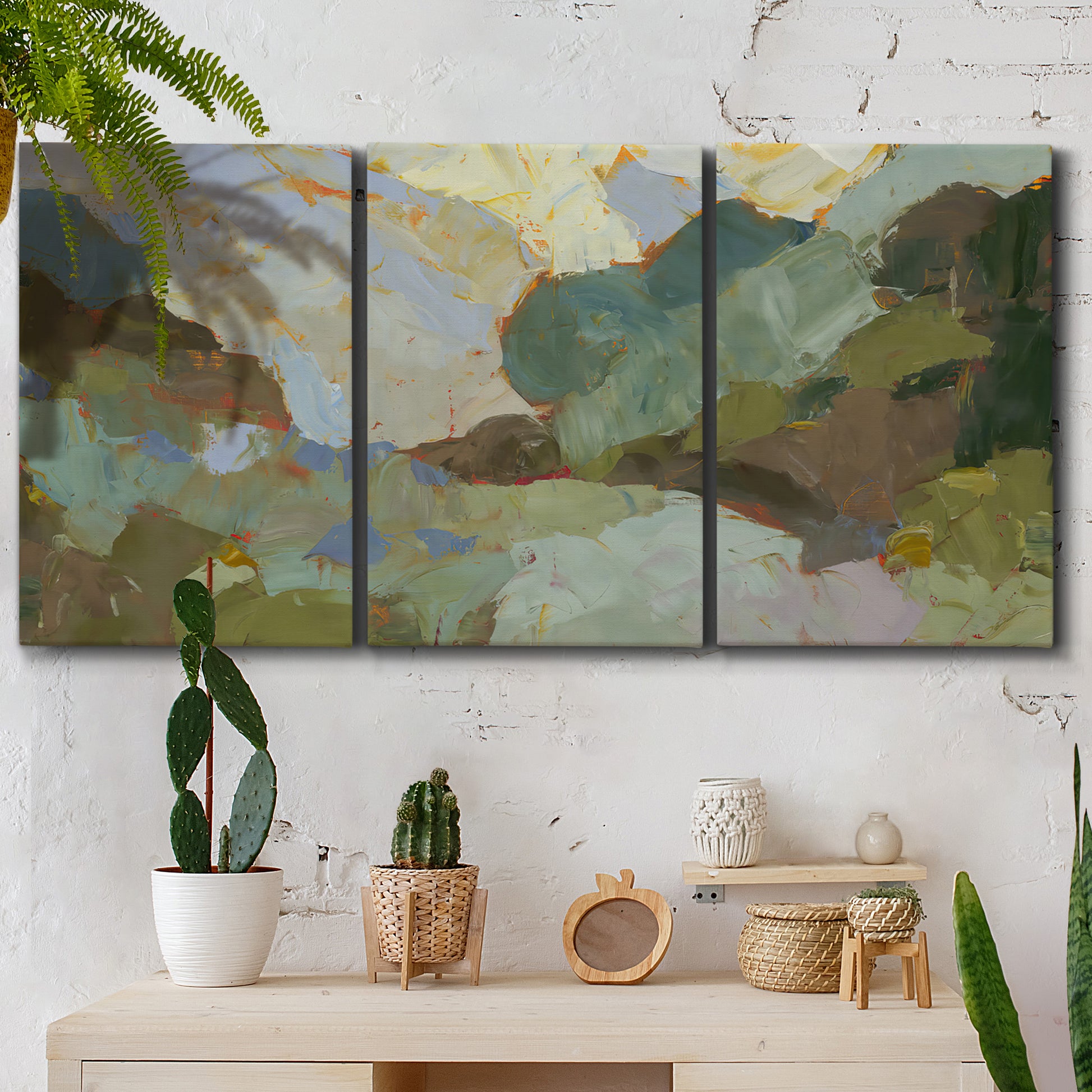 Three-panel canvas wall art featuring abstract landscape suggesting travel pause, displayed in a boho-chic entryway above a console table.