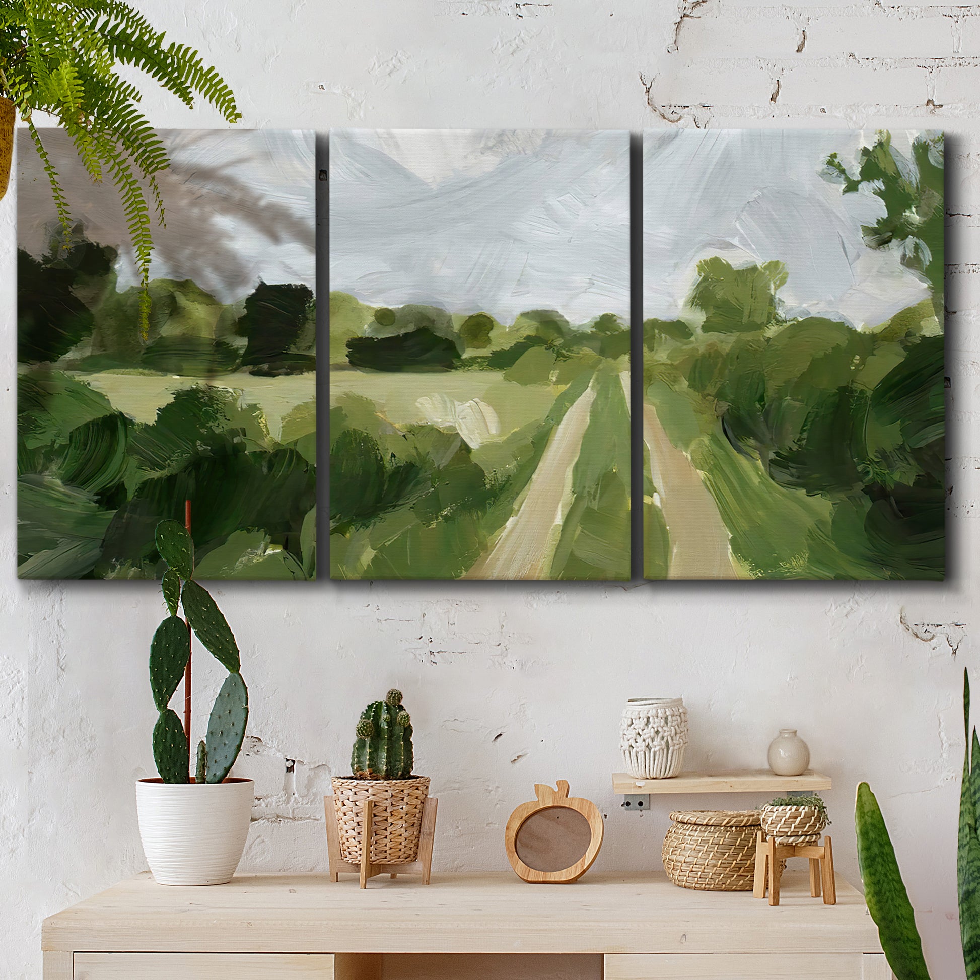 Three-panel canvas wall art featuring meadow trail through open grassland, displayed in a boho-chic entryway above a console table.