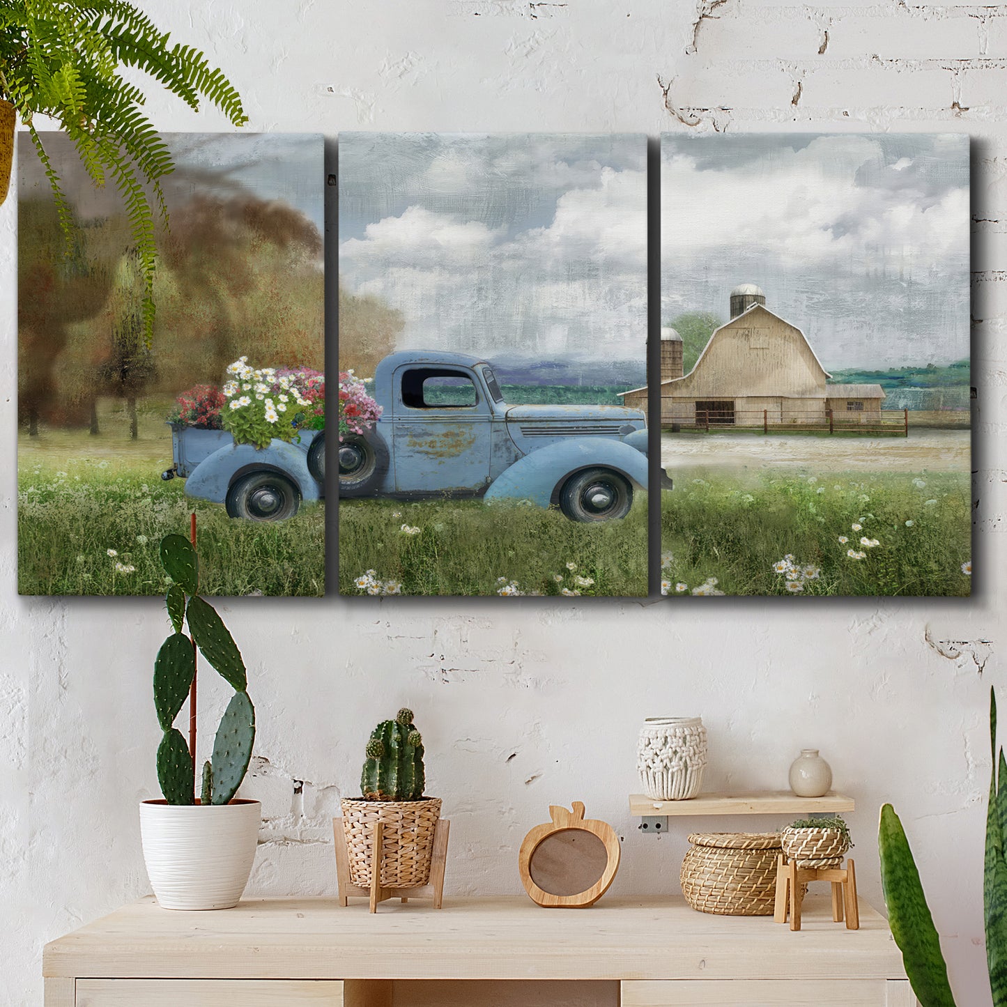 Three-panel canvas wall art featuring vintage blue truck with flower load, displayed in a boho-chic entryway above a console table.