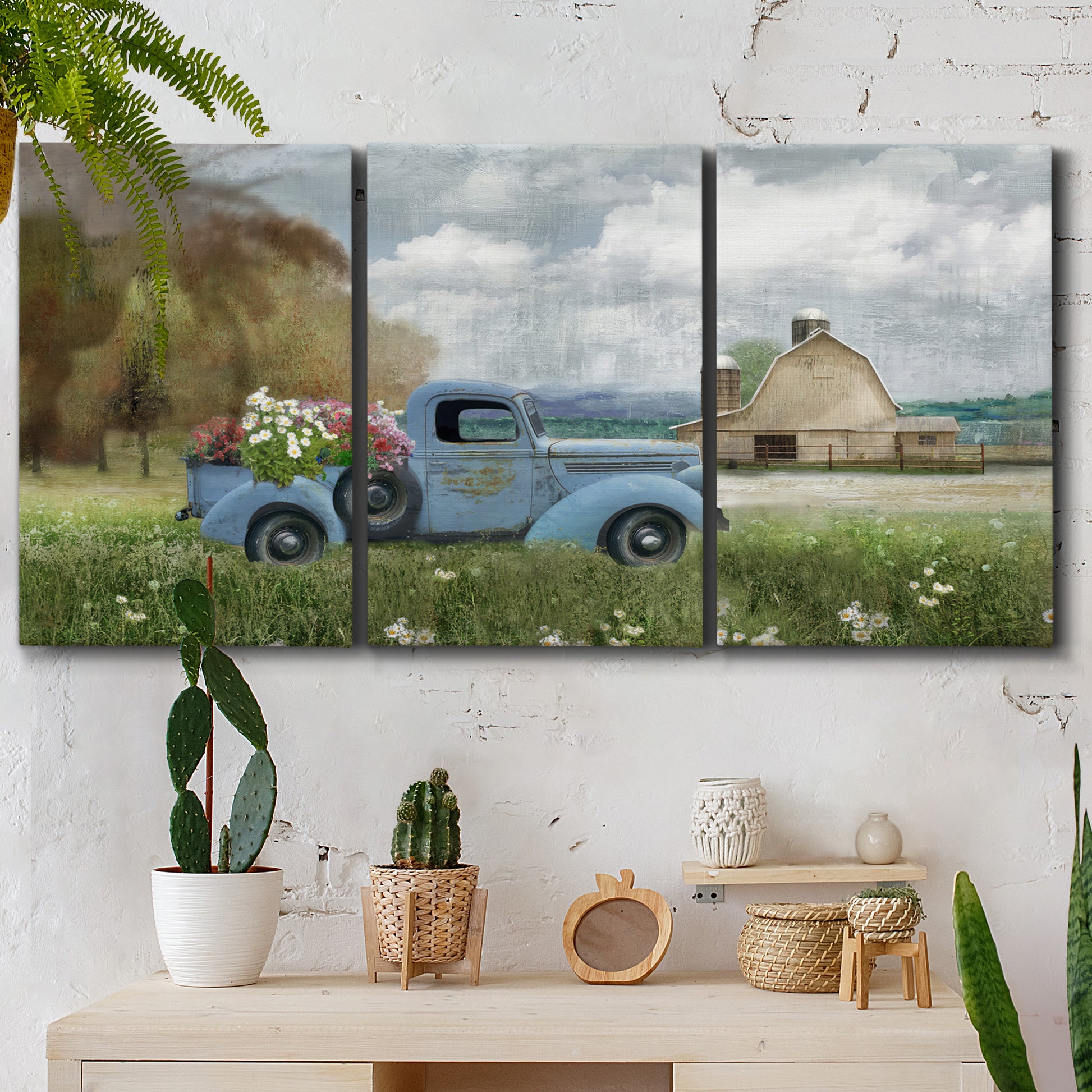 Three-panel canvas wall art featuring vintage blue truck with flower load, displayed in a boho-chic entryway above a console table.