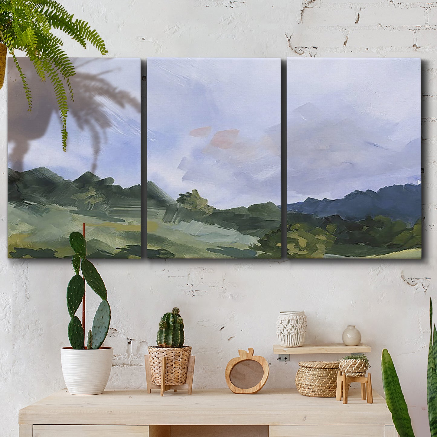 Three-panel canvas wall art featuring wide open pastoral horizon landscape, displayed in a boho-chic entryway above a console table.