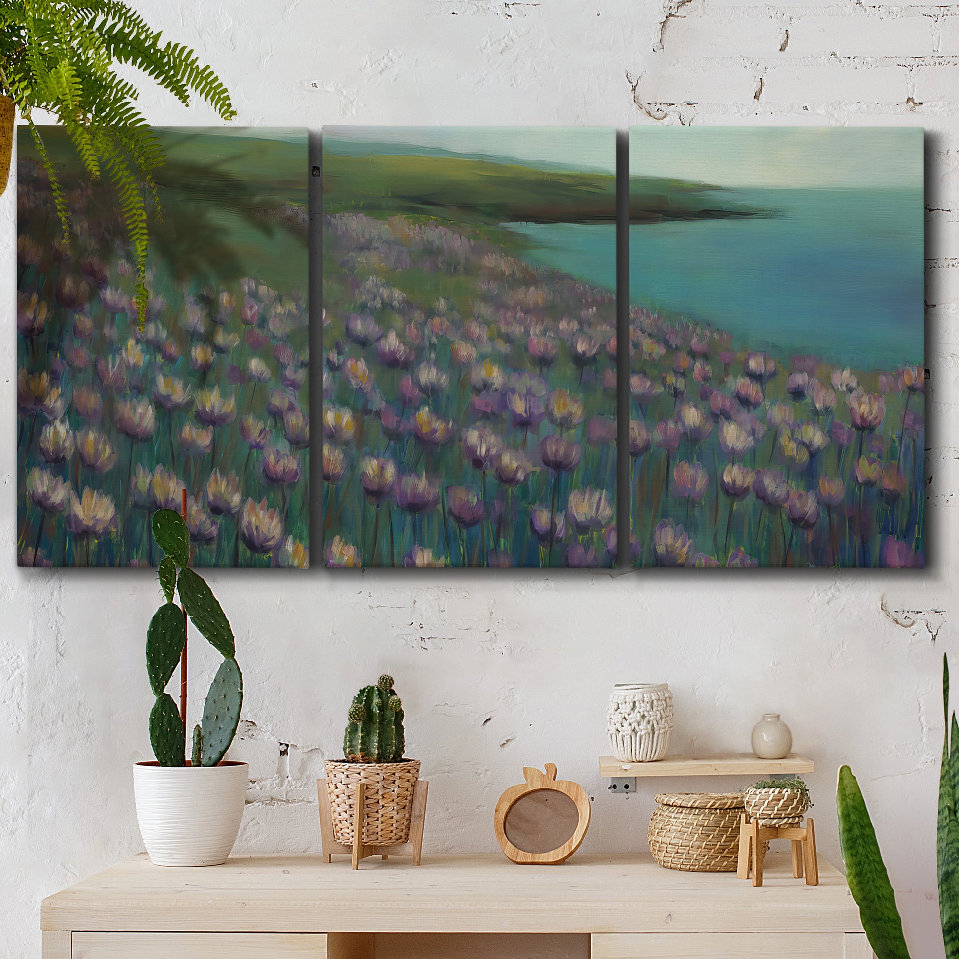 Three-panel canvas wall art featuring calm coastal landscape sanctuary, displayed in a boho-chic entryway above a console table.