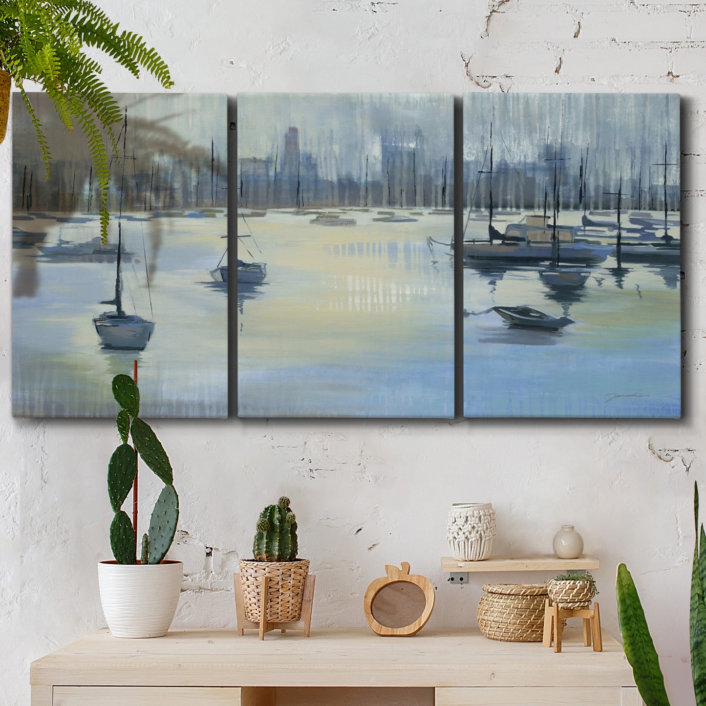 Three-panel canvas wall art featuring anchored boats near shoreline, displayed in a boho-chic entryway above a console table.