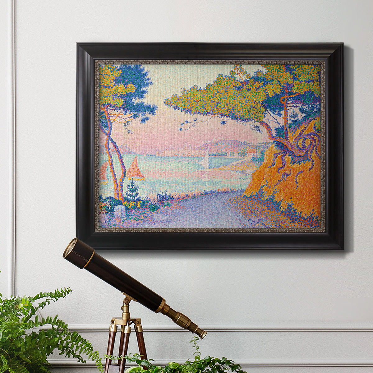 Pointillist coastal seascape by Paul Signac in an ornate black frame with gilded inner detail displayed in a light-toned interior setting.