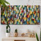 Three-panel canvas wall art featuring colorful confetti style abstraction, displayed in a boho-chic entryway above a console table.