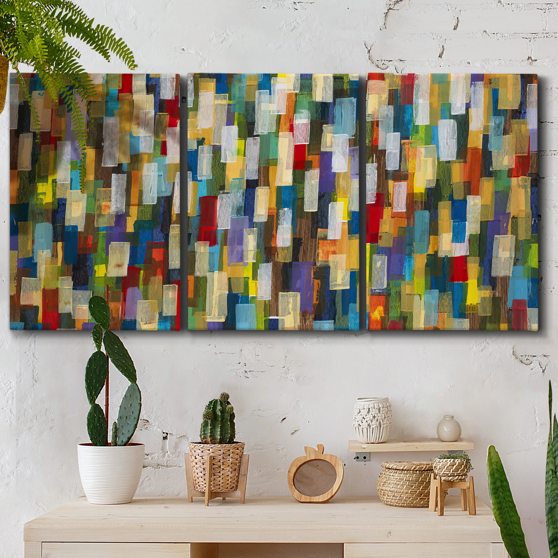 Three-panel canvas wall art featuring colorful confetti style abstraction, displayed in a boho-chic entryway above a console table.