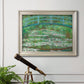 Impressionist garden scene with Japanese bridge and water lilies by Claude Monet in an ornate champagne frame displayed in a light-toned interior setting.