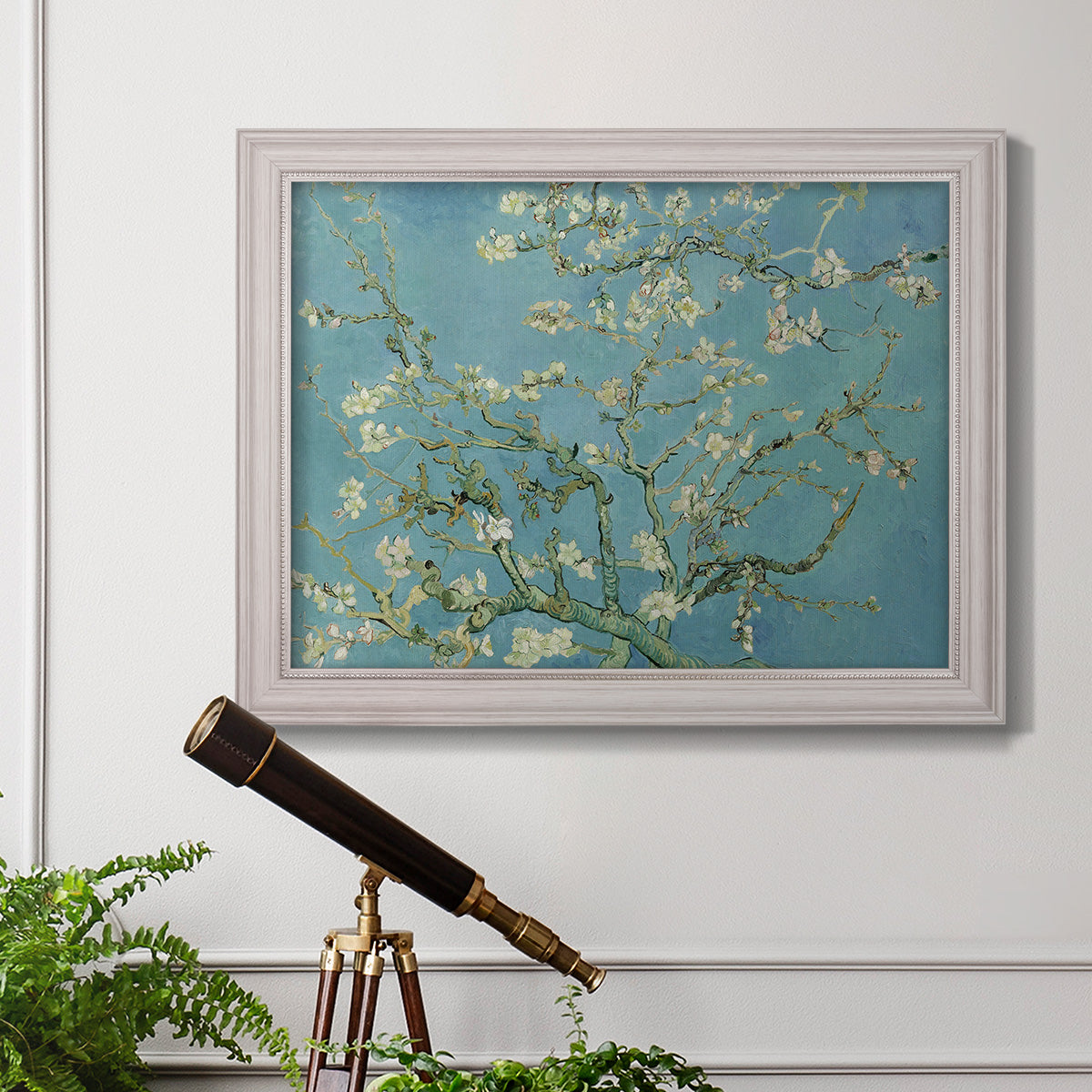 Impressionist flowering almond branch painting by Vincent van Gogh in an ornate weathered white frame displayed in a light-toned interior setting.