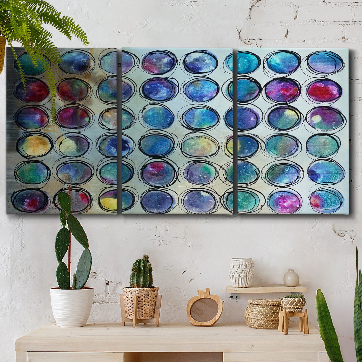 Three-panel canvas wall art featuring contrasting geometric abstract variations, displayed in a boho-chic entryway above a console table.