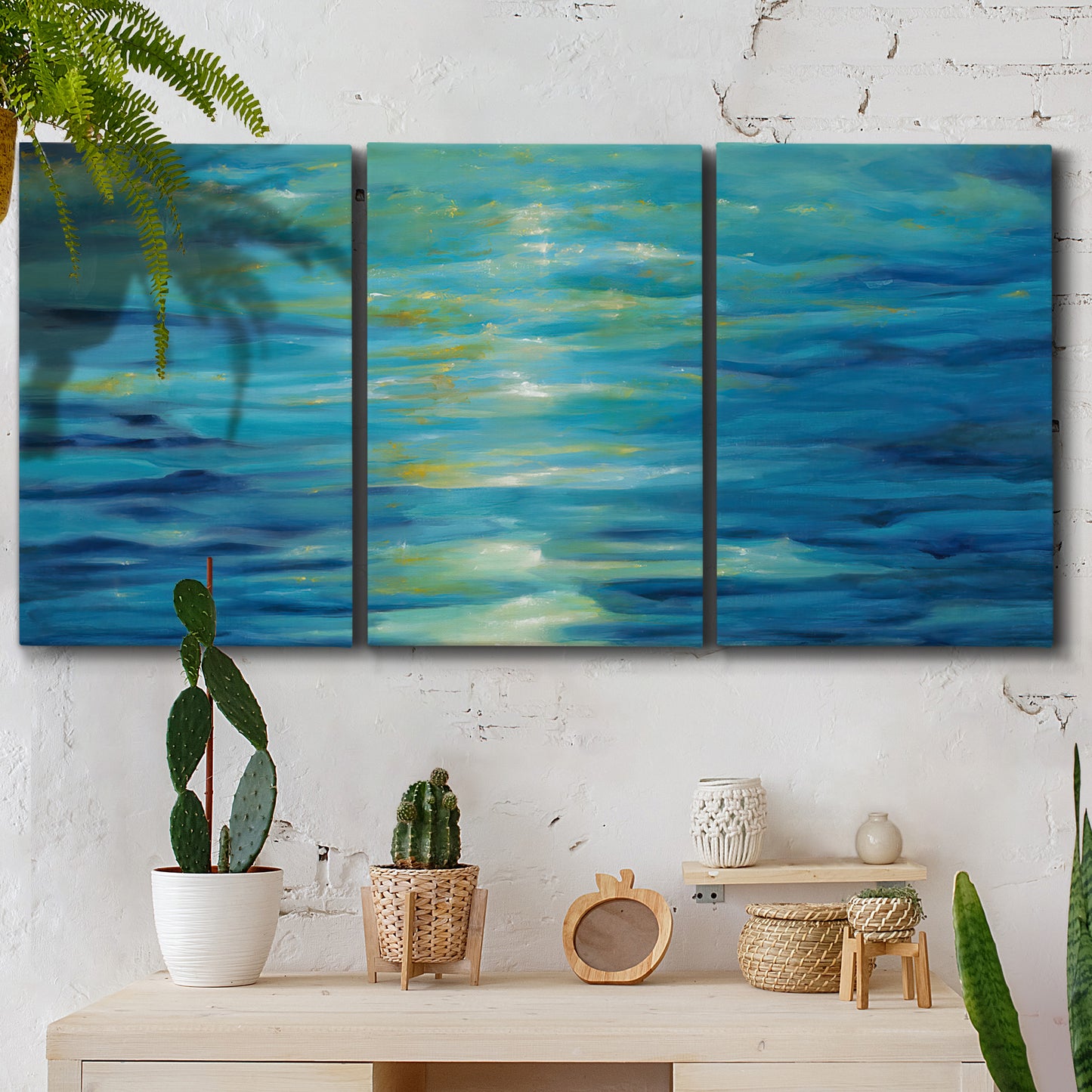 Three-panel canvas wall art featuring deep blue ocean water abstraction, displayed in a boho-chic entryway above a console table.