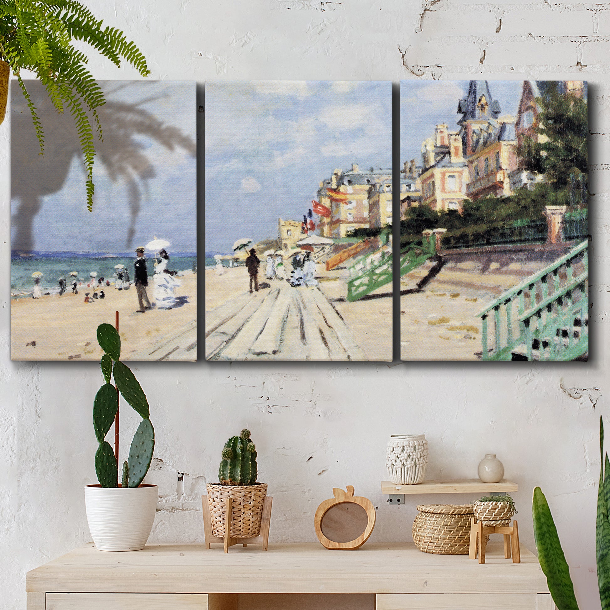 Three-panel canvas wall art featuring figures strolling along beach, displayed in a boho-chic entryway above a console table.