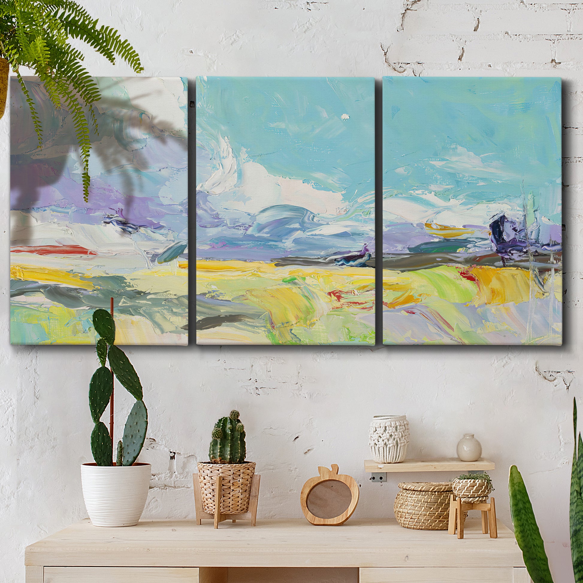 Three-panel canvas wall art featuring open landscape suggesting distant journey, displayed in a boho-chic entryway above a console table.