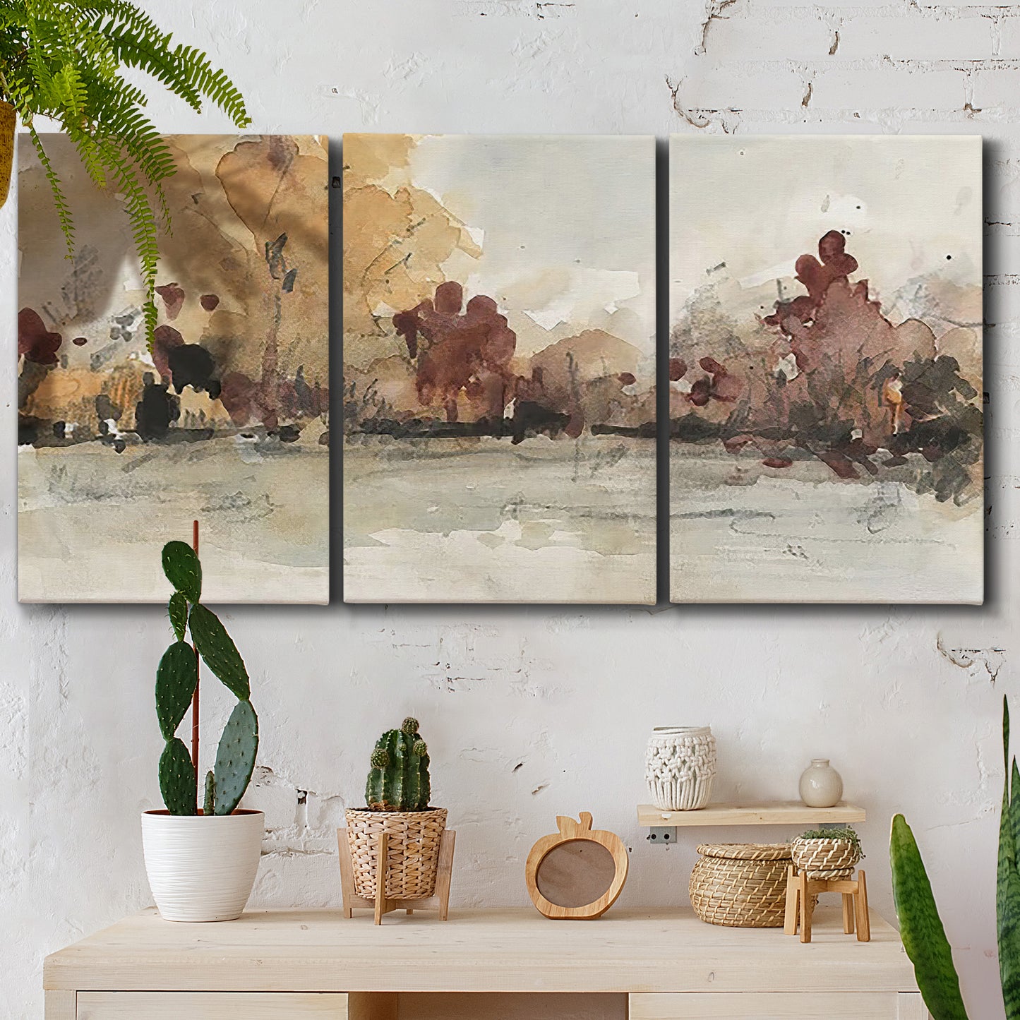Three-panel canvas wall art featuring autumn landscape with trees and field, displayed in a boho-chic entryway above a console table.