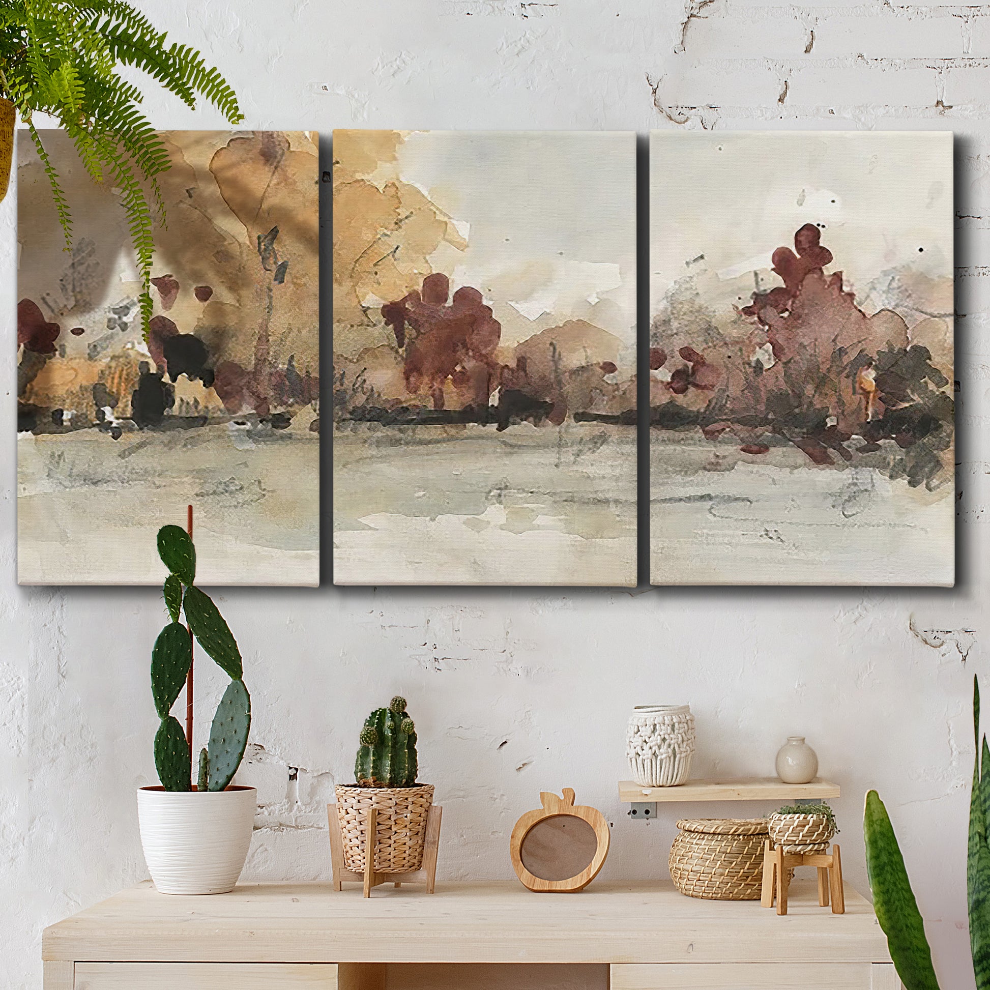 Three-panel canvas wall art featuring autumn landscape with trees and field, displayed in a boho-chic entryway above a console table.