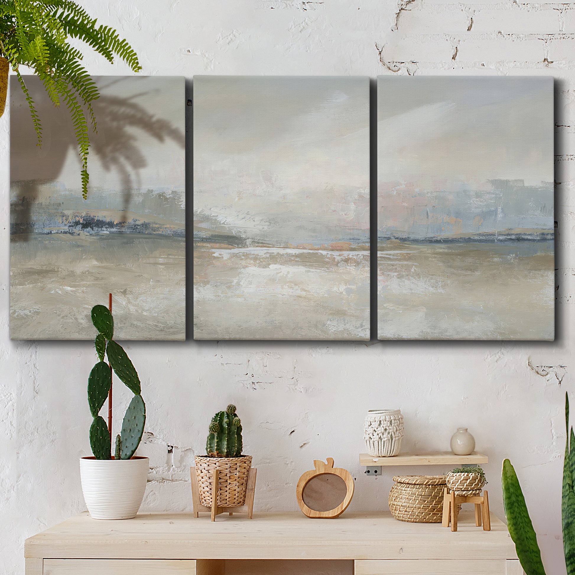 Three-panel canvas wall art featuring soft abstract horizon haze, displayed in a boho-chic entryway above a console table.