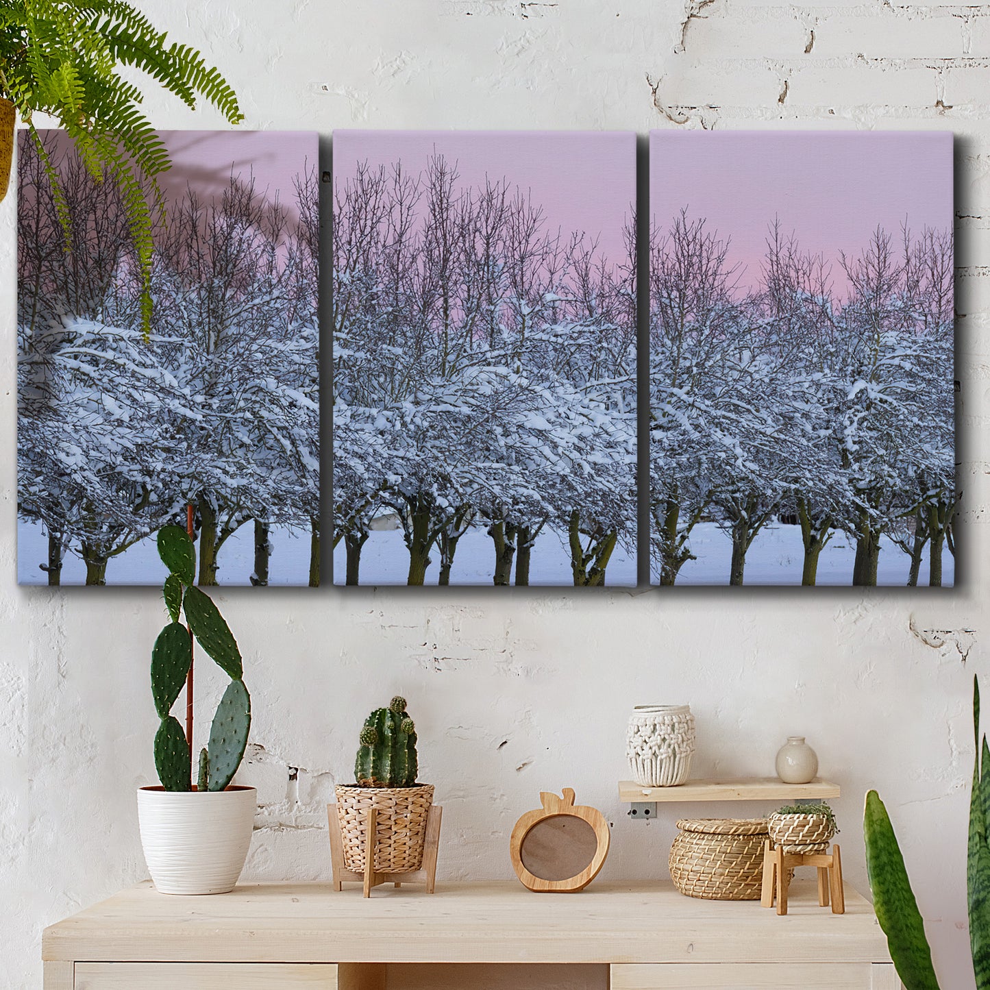 Three-panel canvas wall art featuring winter landscape with bare trees, displayed in a boho-chic entryway above a console table.