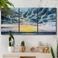 Three-panel canvas wall art featuring tropical coastal sunset over water, displayed in a boho-chic entryway above a console table.