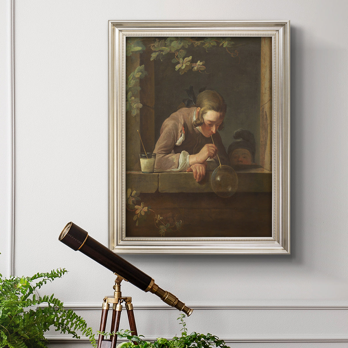 Classical genre painting of a child blowing soap bubbles by Jean-Siméon Chardin in an ornate champagne frame displayed in a light-toned interior setting.