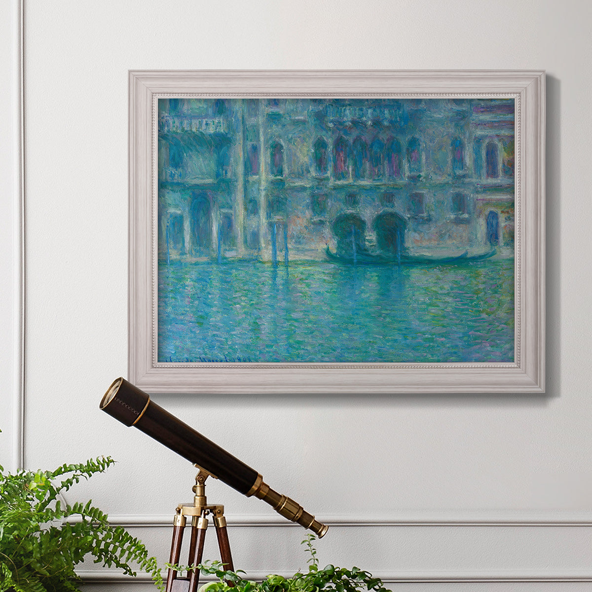 Impressionist Venetian palace waterfront scene by Claude Monet in an ornate weathered white frame displayed in a light-toned interior setting.