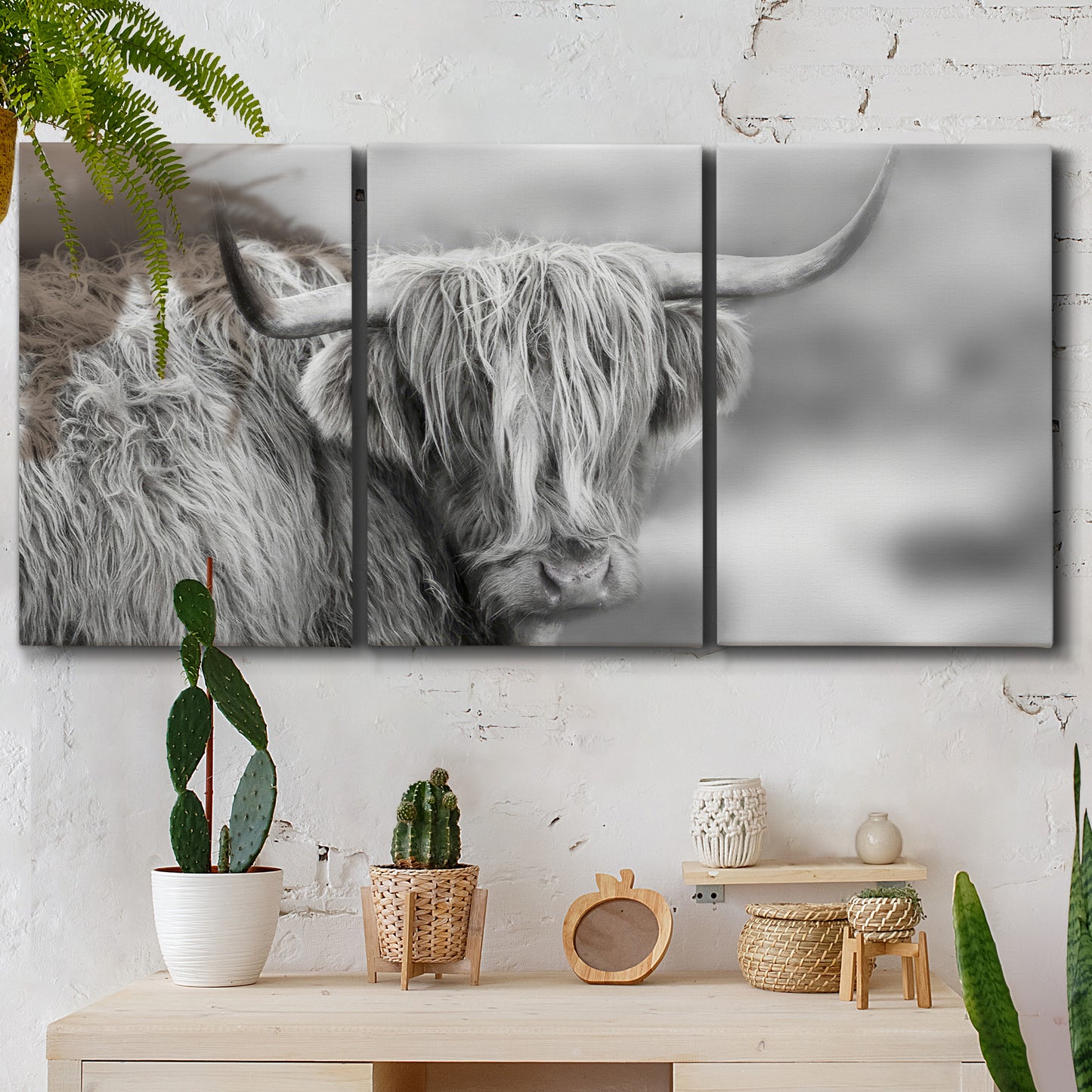 Three-panel canvas wall art featuring large highland cow portrait, displayed in a boho-chic entryway above a console table.