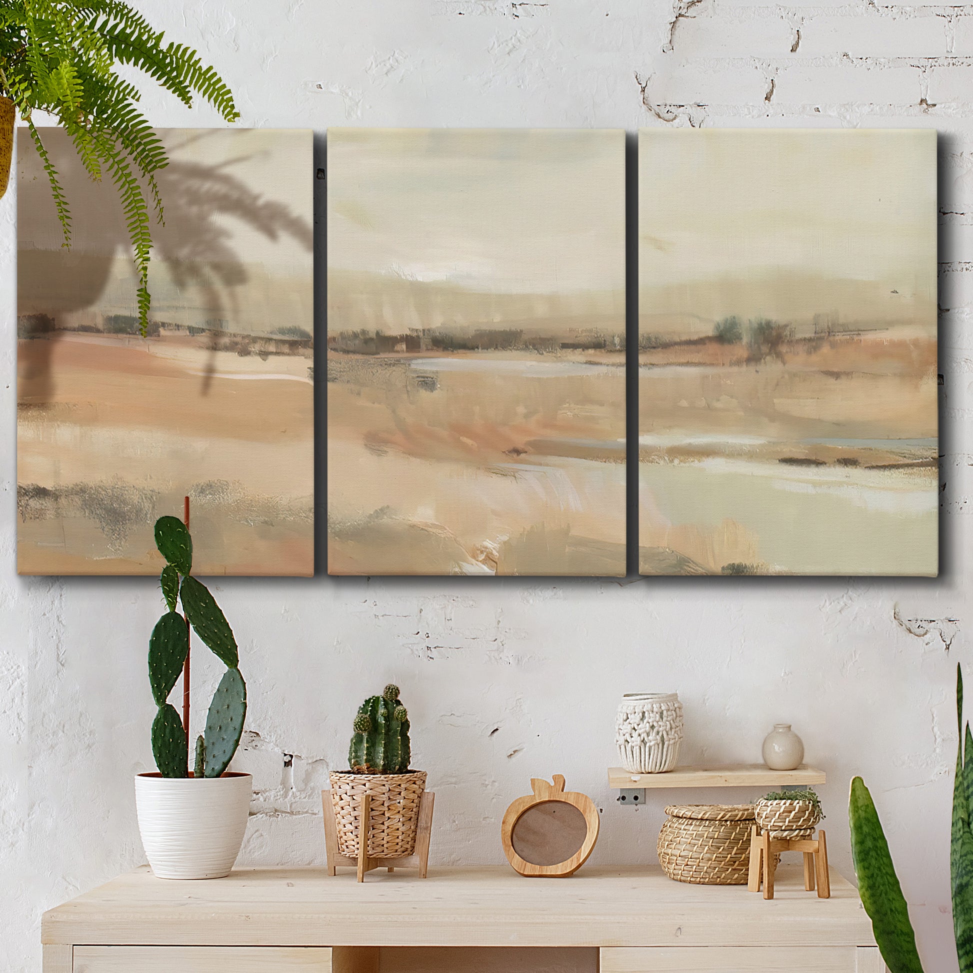Three-panel canvas wall art featuring earth toned abstract landscape, displayed in a boho-chic entryway above a console table.