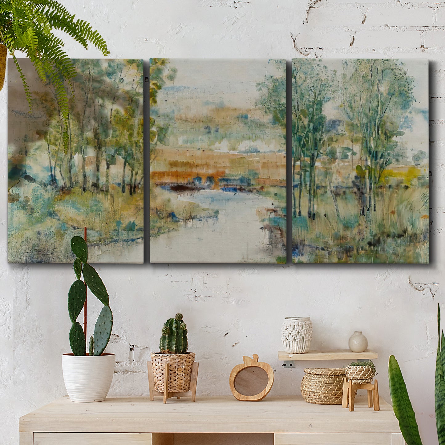 Three-panel canvas wall art featuring trees lining quiet creek, displayed in a boho-chic entryway above a console table.
