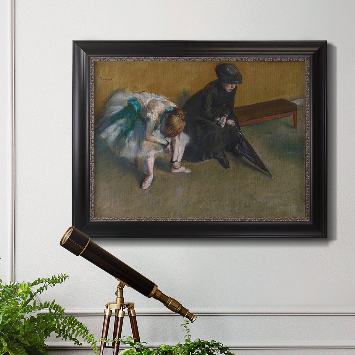 Impressionist portrait of a seated woman by Edgar Degas in an ornate black frame with gilded inner detail displayed in a light-toned interior setting.