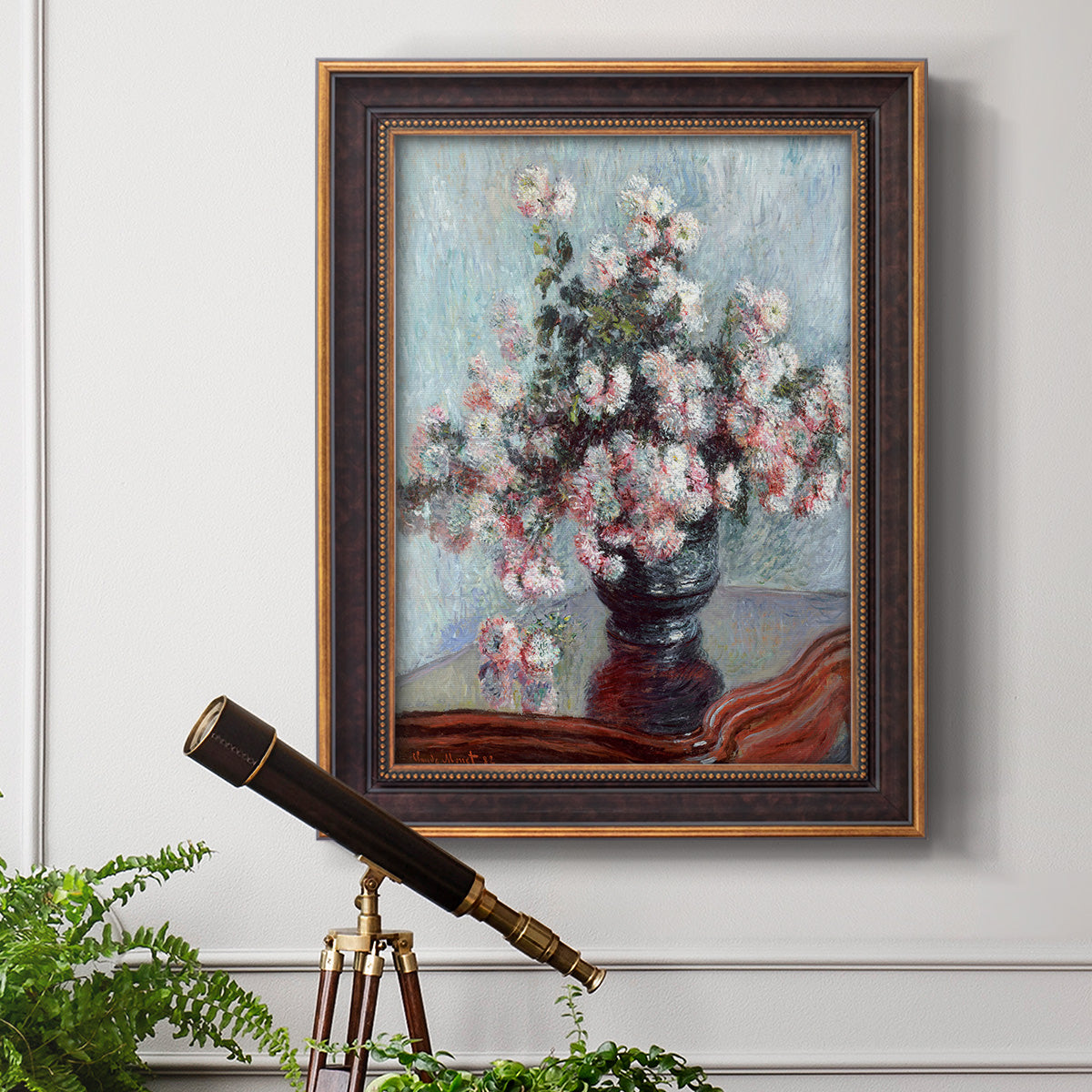 Impressionist chrysanthemum floral painting by Claude Monet in an ornate bronzed mahogany wood frame displayed in a light-toned interior setting.