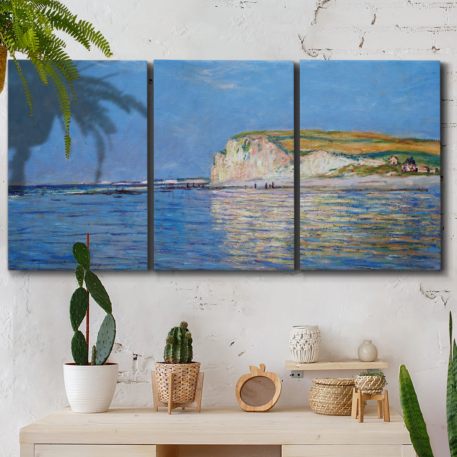 Three-panel canvas wall art featuring white cliffs rising above sea, displayed in a boho-chic entryway above a console table.