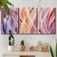Three-panel canvas wall art featuring layered modern abstract color ribbons, displayed in a boho-chic entryway above a console table.