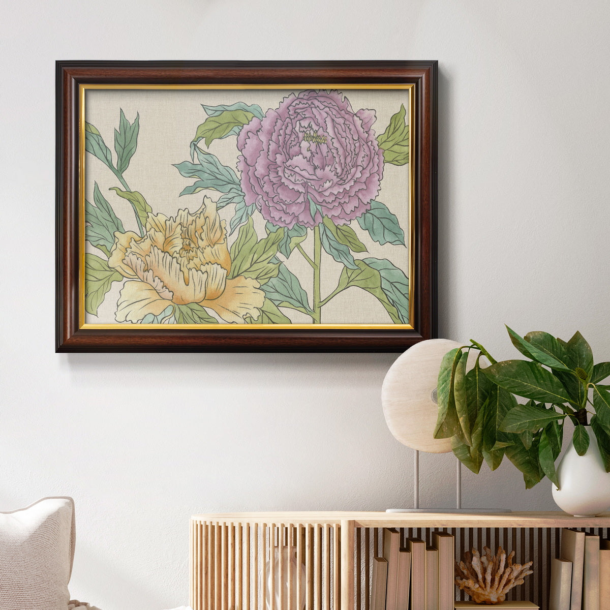 Contemporary peony flower illustration in an ornate mahogany wood frame with gold liner displayed in a light-toned interior setting.