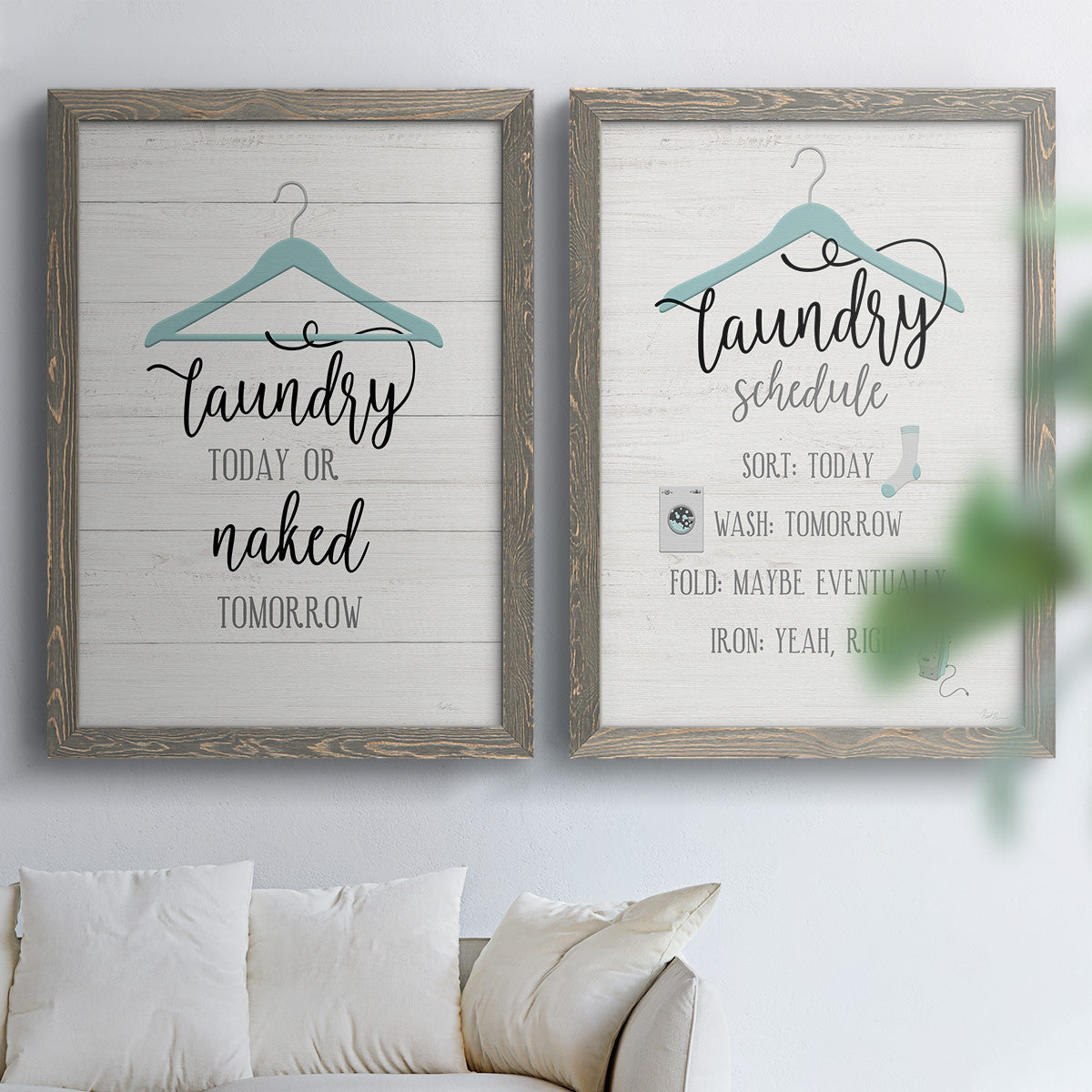 Set of two gray barnwood framed canvas prints depicting hand-lettered phrases, socks hangers and laundry symbols on linen texture arranged across two complementary compositions above a sofa in a bright living space.