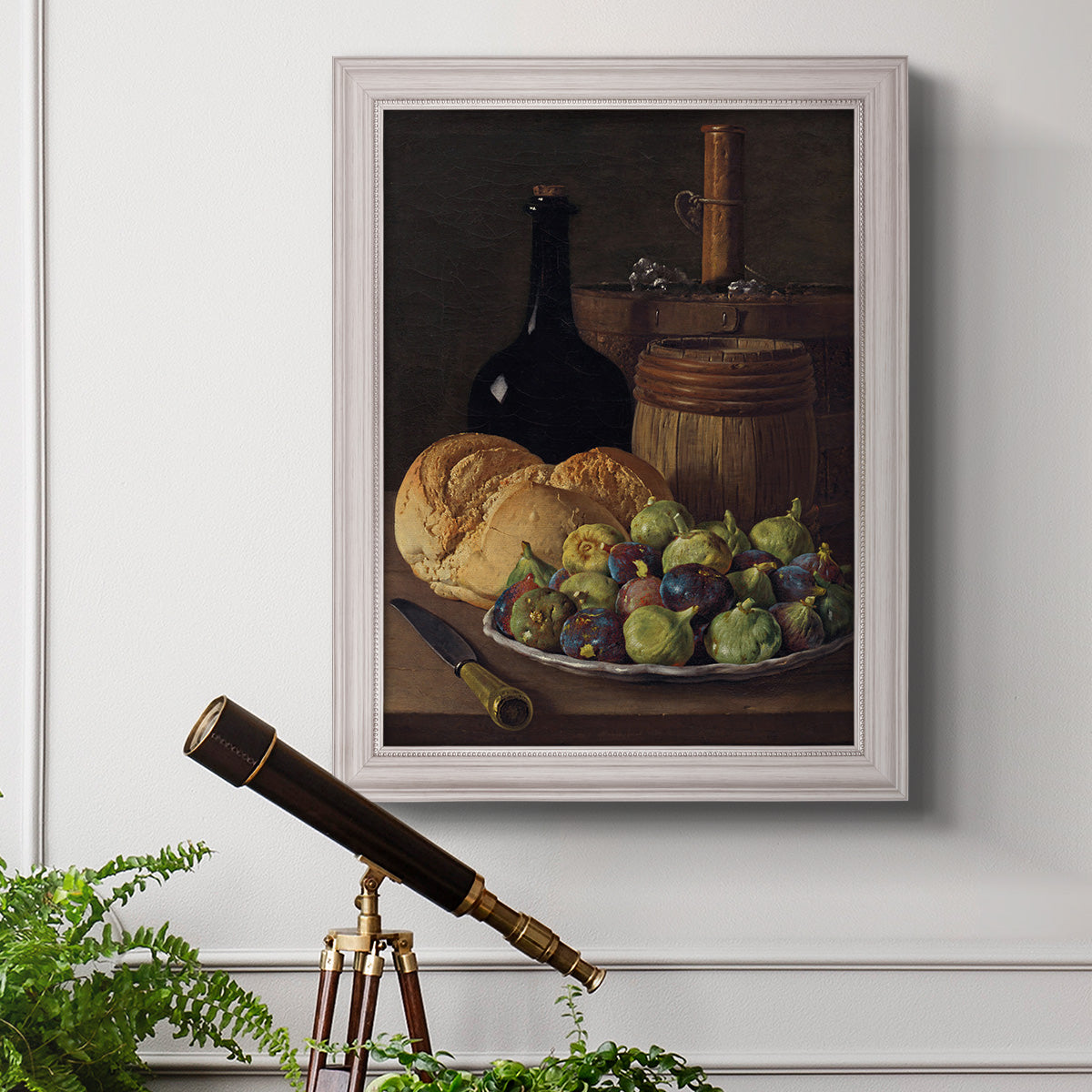 Realist still life with figs and bread by Luis Meléndez in an ornate weathered white frame displayed in a light-toned interior setting.