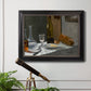 Impressionist still life with wine and bread by Claude Monet in an ornate black frame with gilded inner detail displayed in a light-toned interior setting.