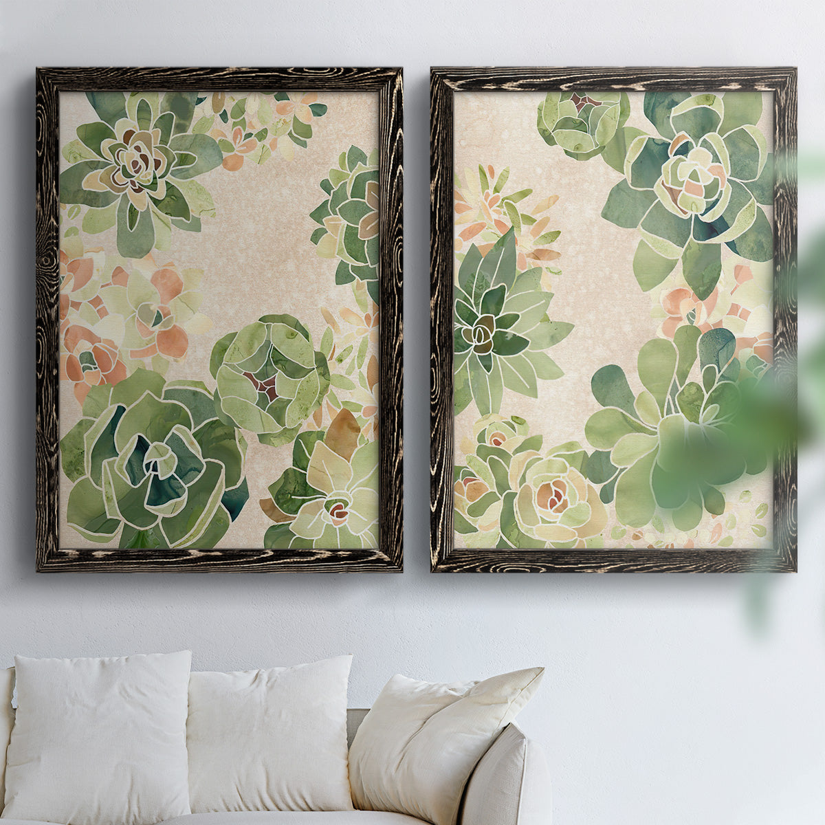 Set of two black barnwood framed canvas prints depicting green rosettes, peach blossoms, and mosaic-like outlines arranged across two complementary compositions above a sofa in a bright living space.