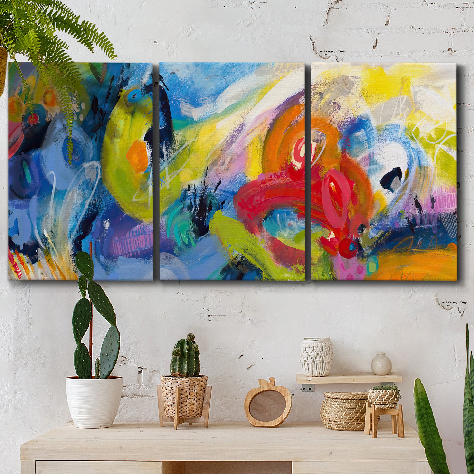 Three-panel canvas wall art featuring colorful abstract racing forms, displayed in a boho-chic entryway above a console table.
