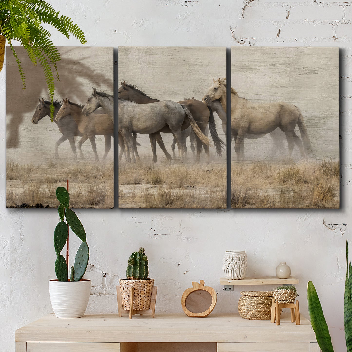 Three-panel canvas wall art featuring wild horses roaming open terrain, displayed in a boho-chic entryway above a console table.