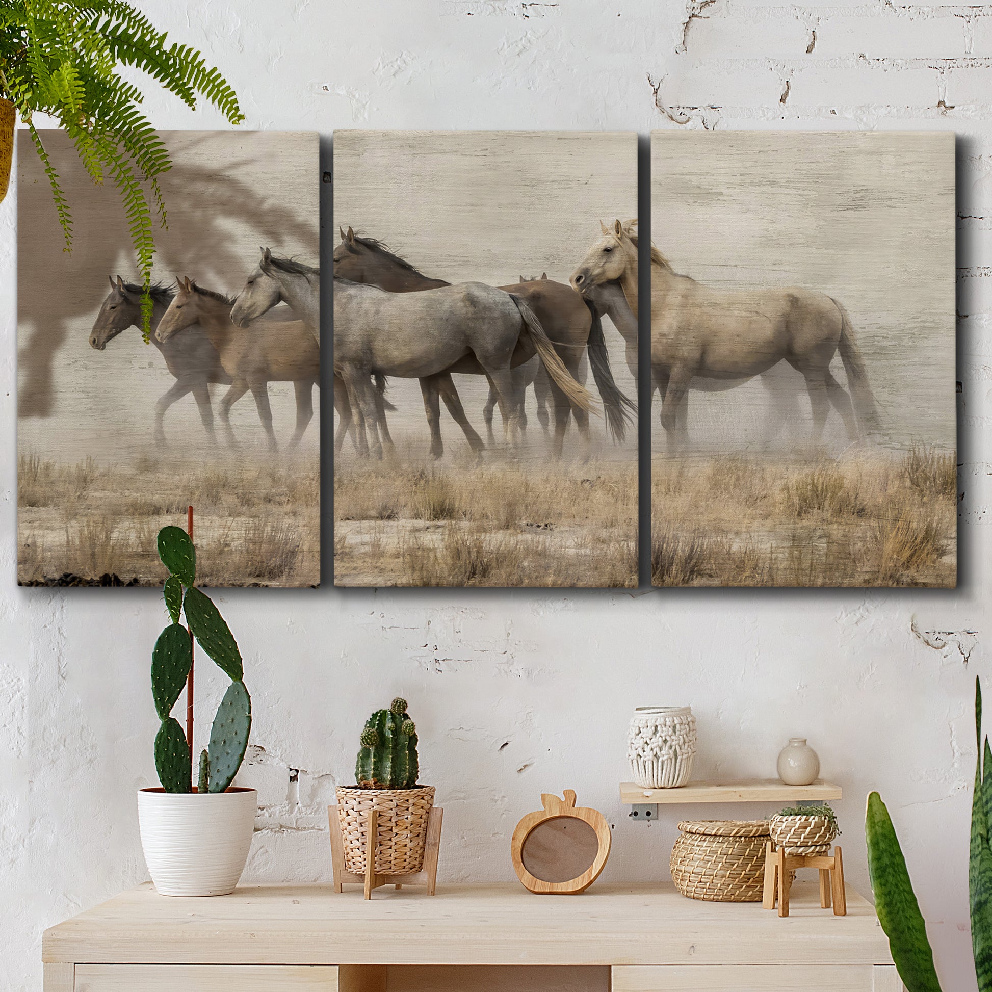 Three-panel canvas wall art featuring wild horses roaming open terrain, displayed in a boho-chic entryway above a console table.