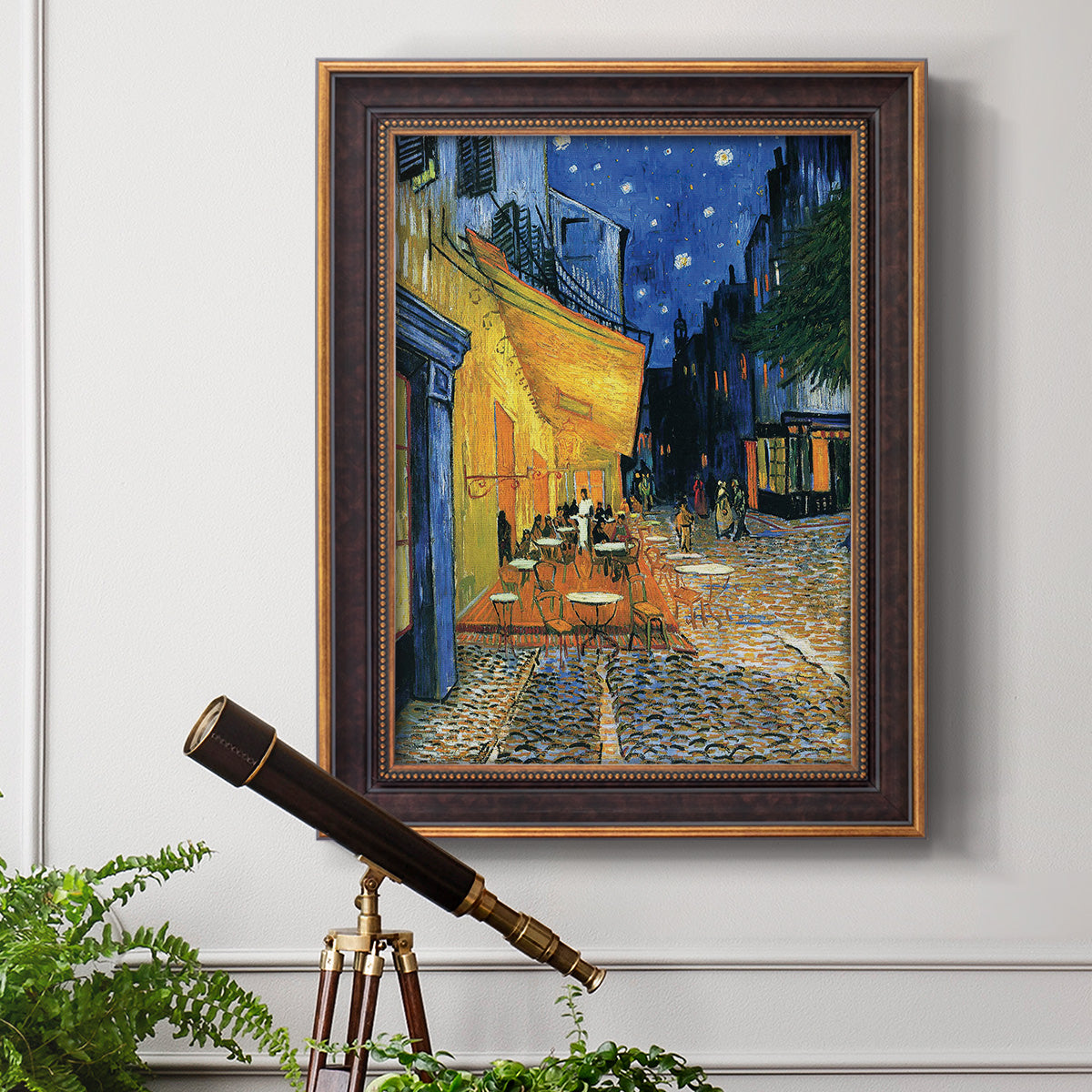Impressionist night café street scene by Vincent van Gogh in an ornate bronzed mahogany wood frame displayed in a light-toned interior setting.
